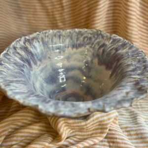 Håndlaget fruktbolle i keramikk med bølget kant og blå-lilla glasur av Caroline Sagafos.