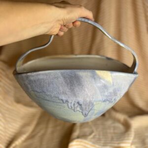 Håndlaget veskeformet keramikkvase med bølgende hank og beige-blå rennende glasur, laget av Caroline Sagafos på Bekkelund Gård & Keramikk.