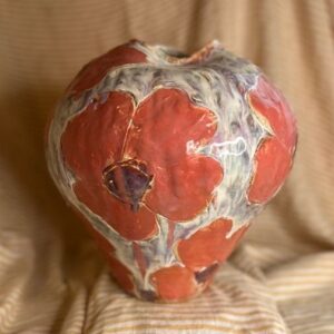 Stor håndlaget keramikkvase med blomsterrelieff i røde og lilla glasurtoner, laget av Caroline Sagafos.