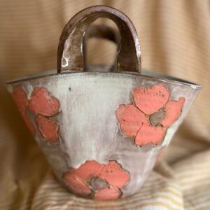 Keramikk veske-vase med store rosa blomster og hvit/rosa glasur, håndlaget av Caroline Sagafos.