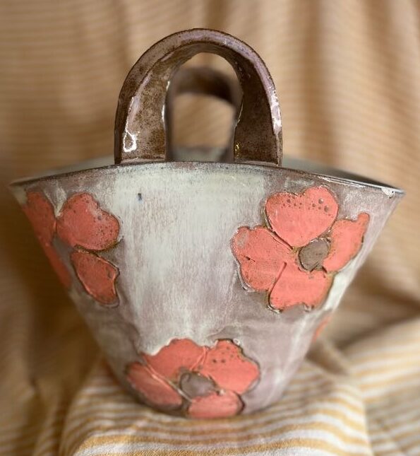 Keramikk veske-vase med store rosa blomster og hvit/rosa glasur, håndlaget av Caroline Sagafos.