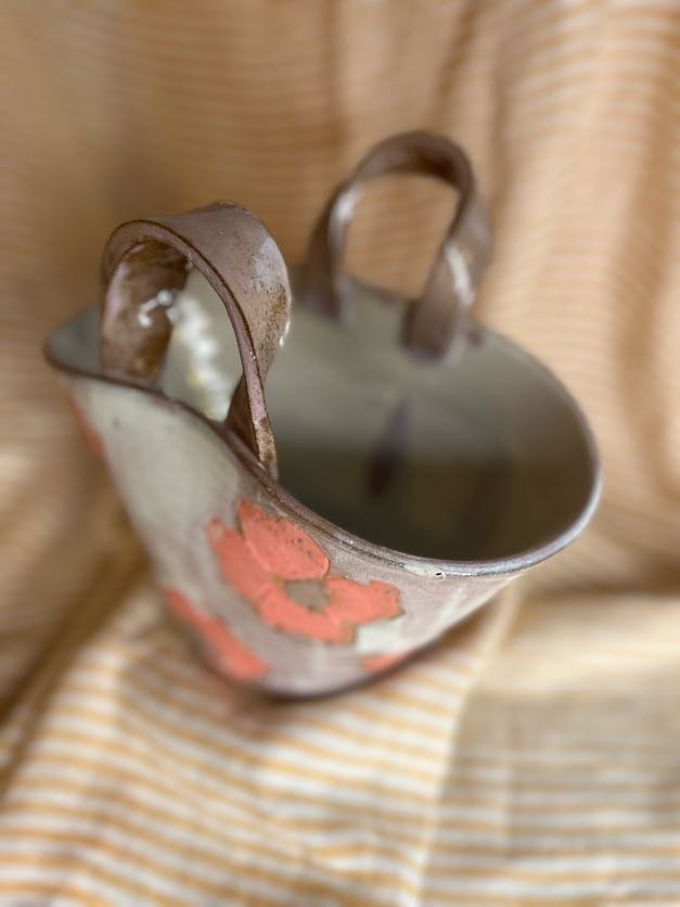 Keramikk veske-vase med store rosa blomster og hvit/rosa glasur, håndlaget av Caroline Sagafos.