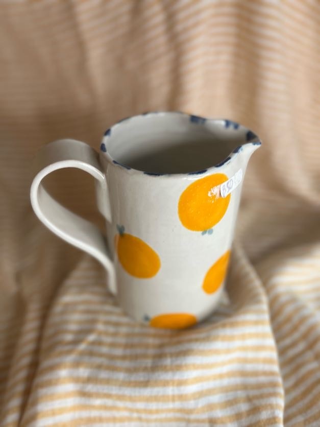 Håndlaget keramikkmugge med håndmalte appelsiner og blå detaljer, laget av Caroline Sagafos på Bekkelund Gård & Keramikk.