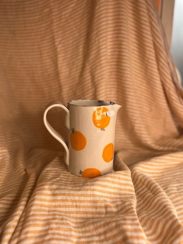 Håndlaget keramikkmugge med håndmalte appelsiner og blå detaljer, laget av Caroline Sagafos på Bekkelund Gård & Keramikk.