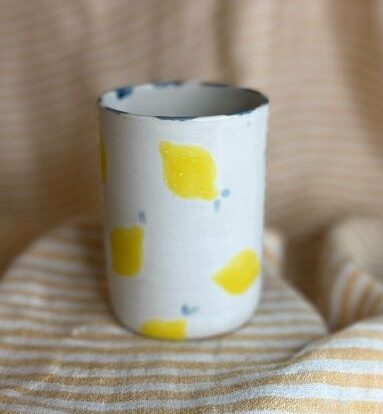 Håndlaget lattekopp i keramikk med sitronmotiv og blå detaljer, laget av Caroline Sagafos.
