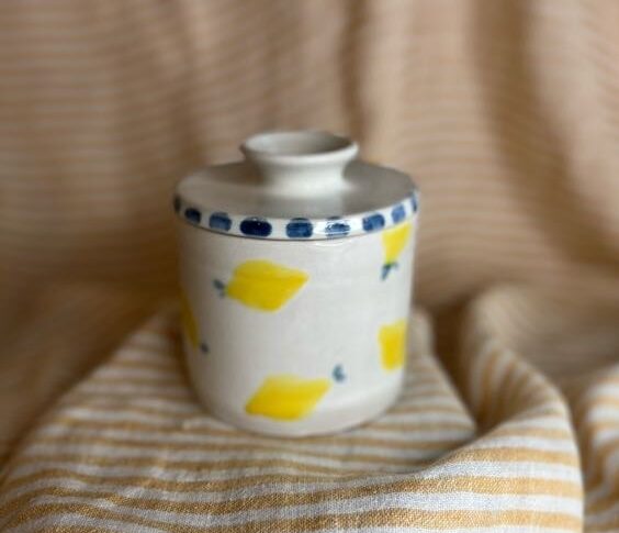 Håndlaget keramikk smørklokke med sitronmotiv og blå prikker på lokket, laget av Caroline Sagafos.