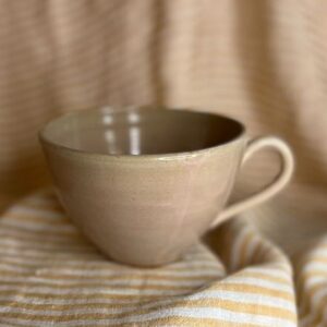 Håndlaget tekopp i keramikk med hank og myk rosabeige glasur, laget av Caroline Sagafos.