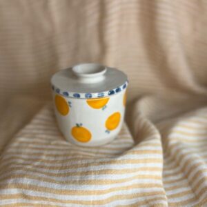 Håndlaget keramikk-smørklokke med hvit glasur, håndmalte appelsiner og blå prikker på lokket, laget av Caroline Sagafos.