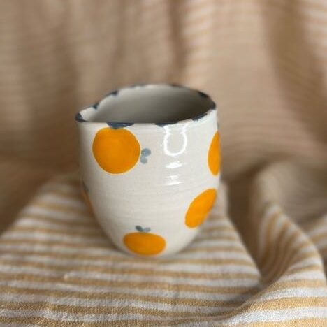 Liten håndlaget fløtemugge i keramikk med appelsinmotiv og blå detaljer, laget av Caroline Sagafos.
