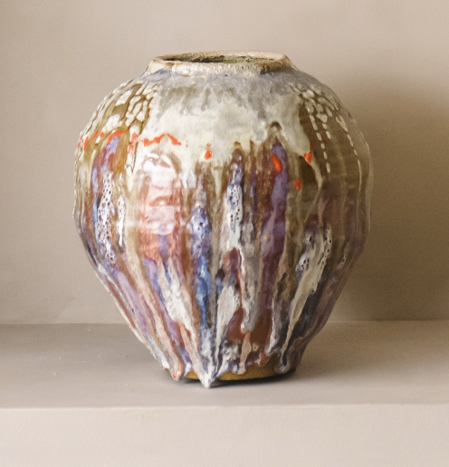 Håndlaget kunstvase med flytende glasur i kremhvite, lilla og varme toner.