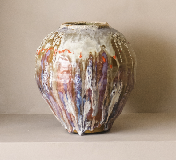 Håndlaget kunstvase med flytende glasur i kremhvite, lilla og varme toner.