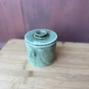 Håndlaget smørklokke i grønnblå matt glasur med minimalistisk keramisk design.